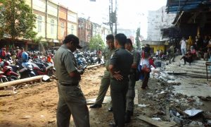 Anggota Pol-PP Palembang berjaga-jaga di sudut Gedung Pasar 16 Ilir pasca-dirobohkannya petak bangunan milik PKL. 