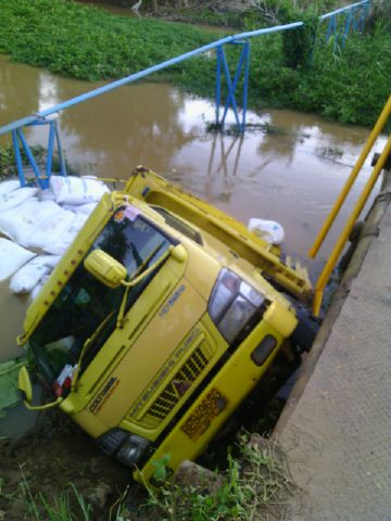 Terguling_IST_Sebuah truk bermuatan pakan ternak terguling. TErgulingnya truk disebabkan jembatan yang sudah lama rusak