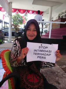  Salah satu jurnalis menunjukan tulisan berisikan penolakan aksi kekerasan terhadap wartawan di sela-sela unjuk rasa, Selasa (16/8). 
