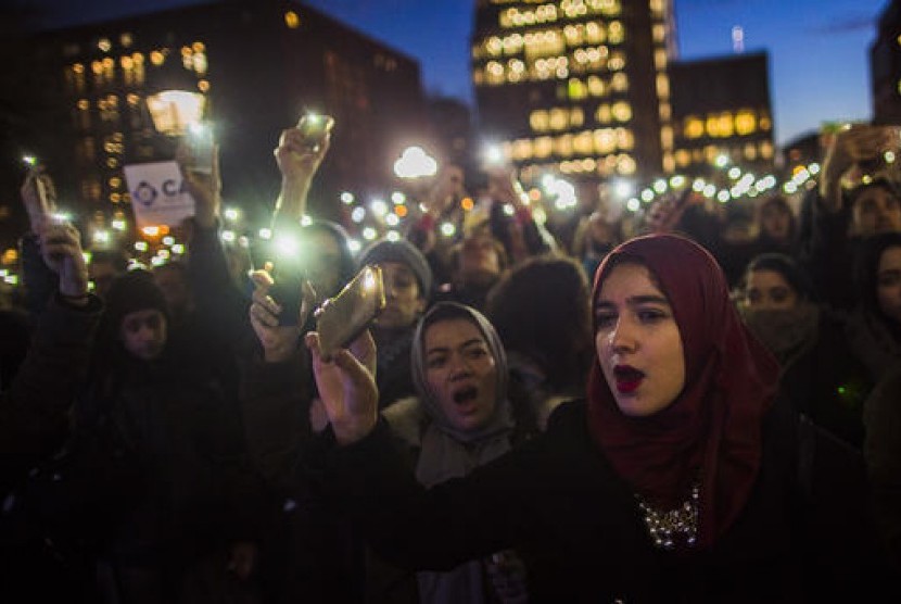 Pengunjuk rasa menentang kebijakan Trump terkait pembatasan imigran muslim.