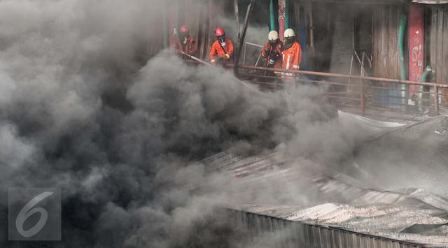 Petugas pemadam kebakaran berjibaku memadamkan api yang menghanguskan ribuan kios di Pasar Senen.