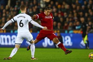 Penyerang Liverpool FC, Roberto Firmino (kanan), berduel dengan bek Swansea City, Alfie Mawson
