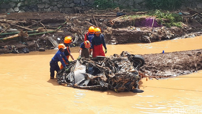 Petugas Damkar Bandung mengevakuasi bangkai mobil yang hanyut dihantam banjir bandang.