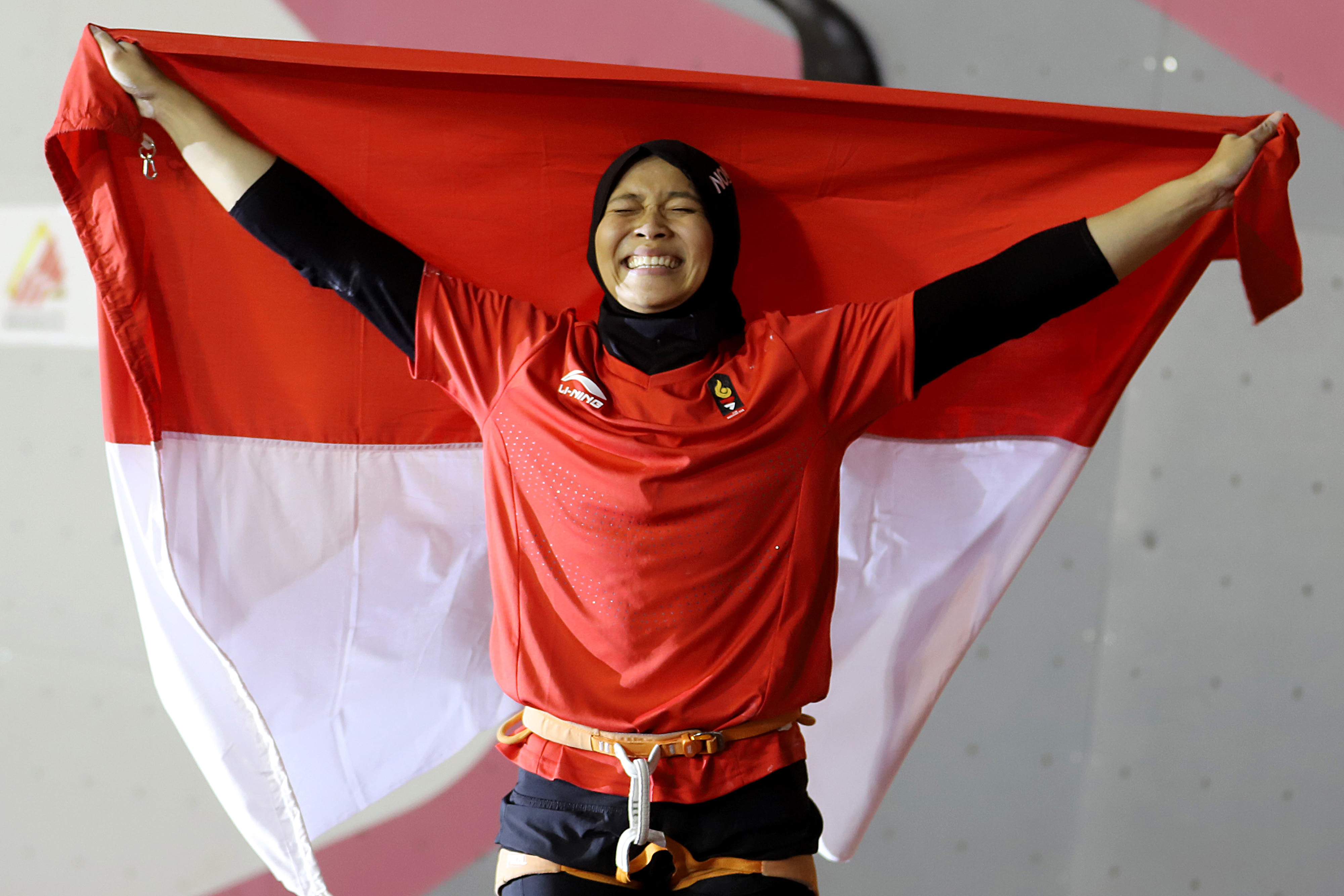 Atlet panjat tebing Indonesia Aries Susanti Rahayu mengibarkan Bendera Merah Putih setelah berhasil meraih medali emas pada kategori speed Asian Games 2018 di Arena Panjat Tebing Jakabaring Sport City, Palembang, Sumatera Selatan, Kamis (23/8)