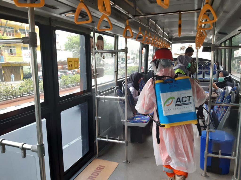 Relawan ACT saat menyemprotkan disinfektan.