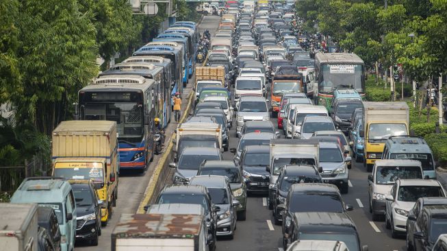 Sejumlah kendaraan bermotor antre melewati posko penyekatan di Jalan Salemba Raya
