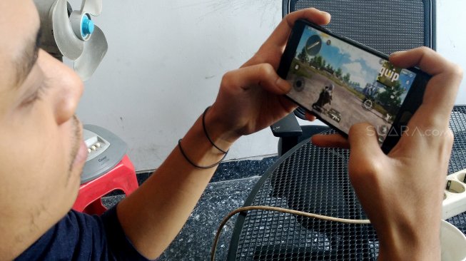 Ilustrasi Warga bermain game Player Unknown's Battle Grounds (PUBG) melalui telepon pintar
