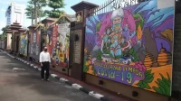 Warga melintas di dekat mural bertema Covid-19 di Jakarta