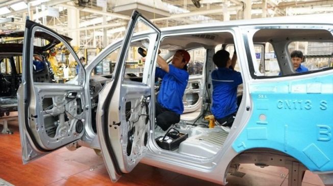 Ilustrasi pekerja sedang merakit mobil di sebuah pabrik otomotif.